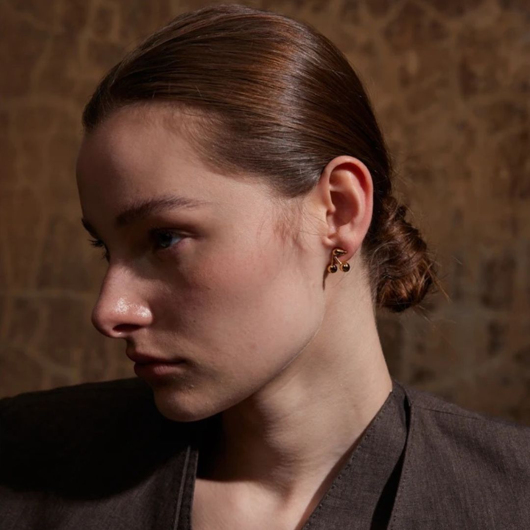 femme porte une belle boucle d'oreille acier inoxydable doré