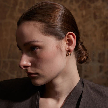 femme porte une belle boucle d'oreille acier inoxydable doré