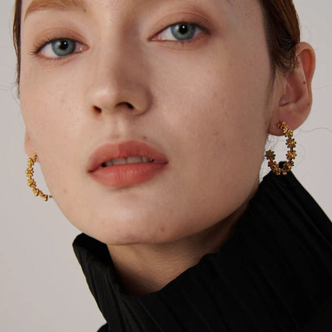 femme porte notre boucle d oreille fleur en acier inoxydable plaqué en or 