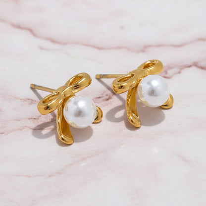 une boucle d oreille noeud couleur doré avec perle en acier