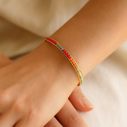 Look parisien avec un bracelet femme tendance assorti à une bague fine.