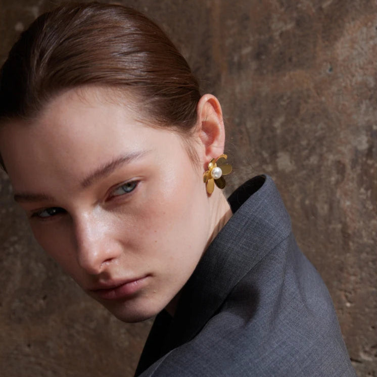 femme porte notre belle boucle d oreille fleur en acier couleur doré plaqué en or